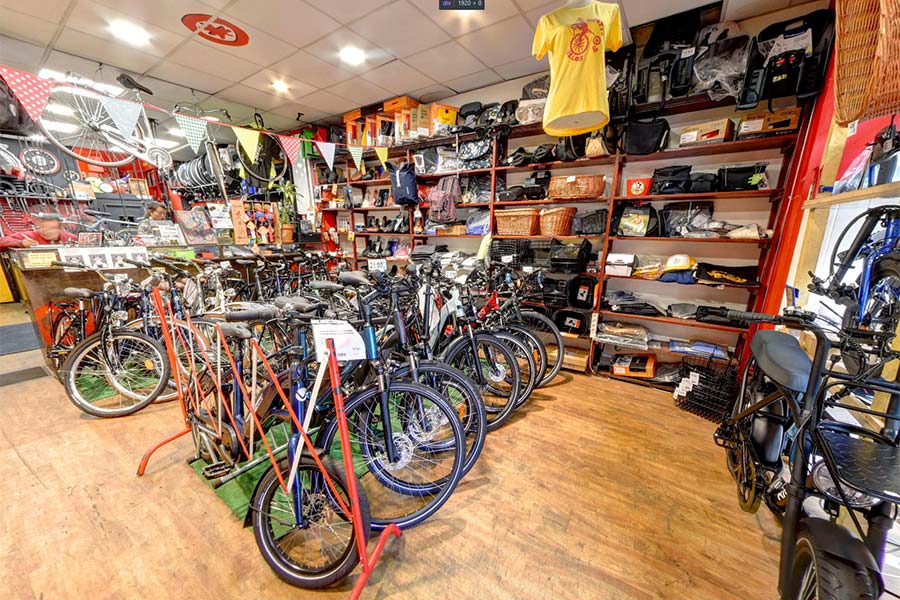 L'intérieur du magasin avec la vente de vélos neufs et des accessoires